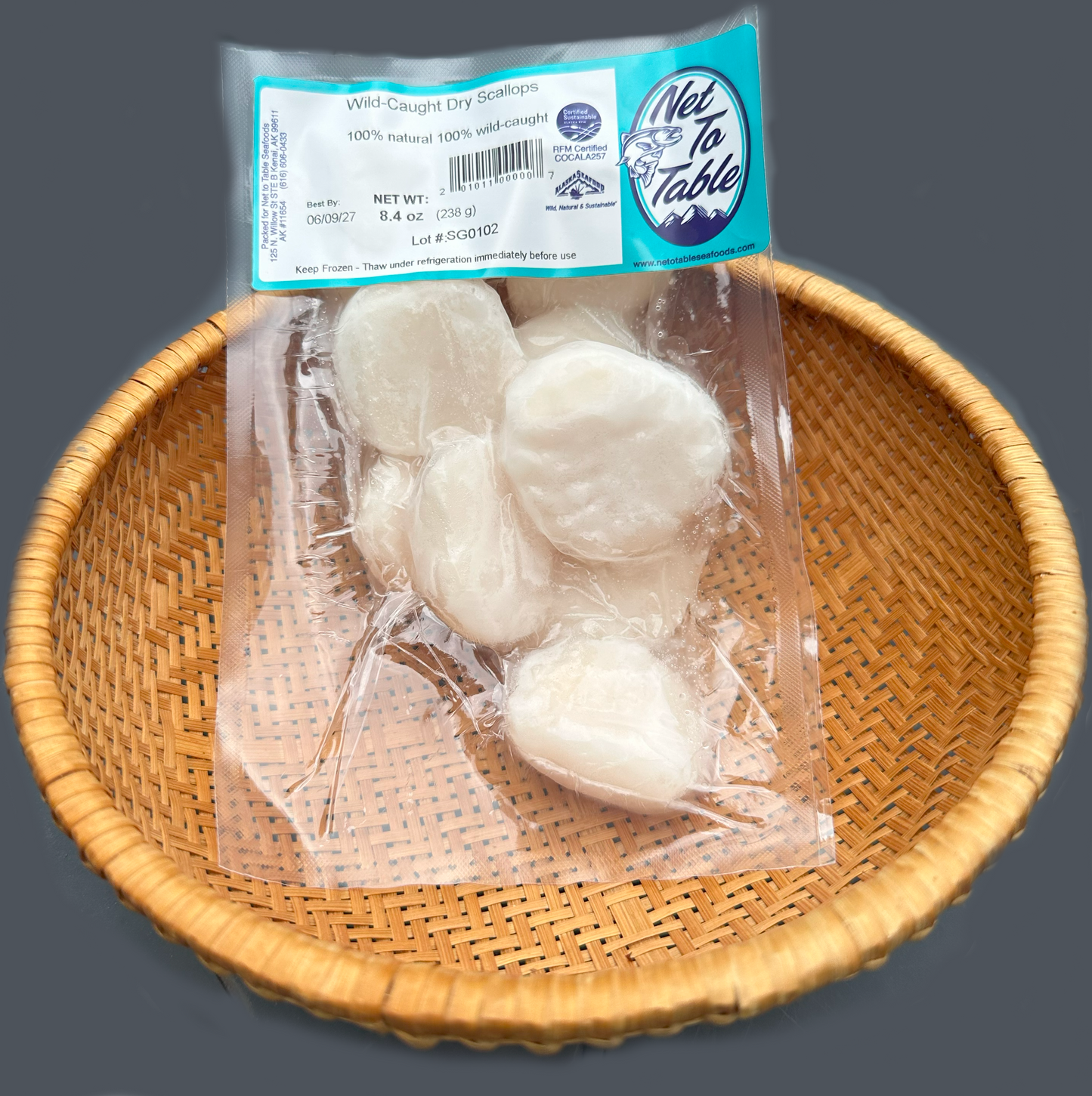 Package of wild-caught dry scallops from Net to Table Seafoods in woven basket, sustainably harvested Alaskan scallops, 100% natural chemical-free flash-frozen