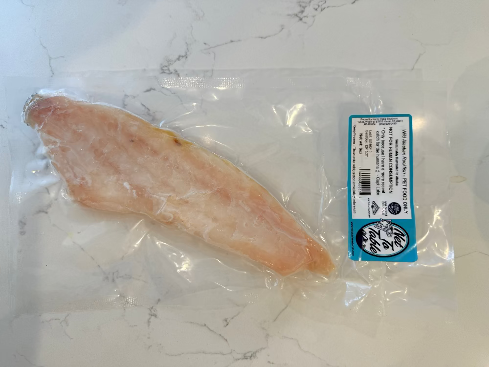 Raw fish fillet in a clear plastic bag with a label on a marble surfaceVacuum-sealed package of Wild Alaskan Rockfish labeled “Pet Food Only” from Net to Table Seafoods. Sustainably harvested wild-caught fish from Alaska, part of the family-owned company’s healthy natural pet food line. Net to Pet 

