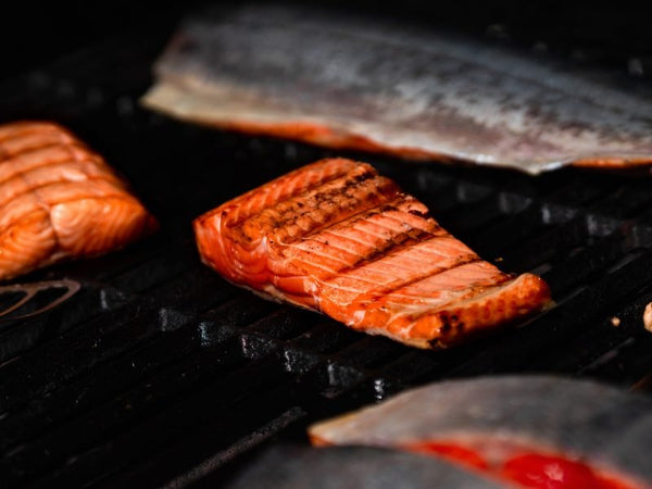 Alaskan Sockeye Salmon Box - Net To Table Seafoods Wild-caught Alaskan salmon fillets grilling to perfection, showing crispy seared edges and rich orange color that highlight freshness, flavor, and sustainable seafood quality.
